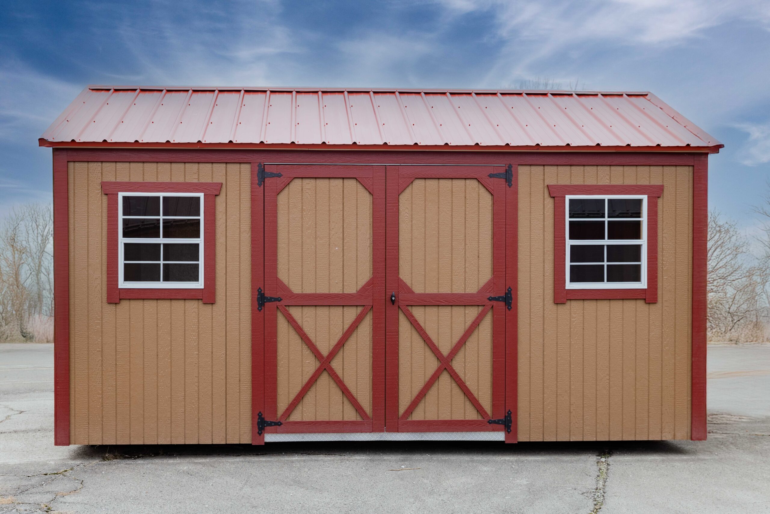 the front of a light brown garden shed with red trim and a red metal roof