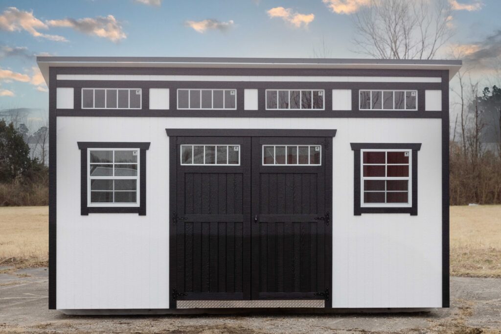 a white studio shed with black doors, two windows, and four transom windows