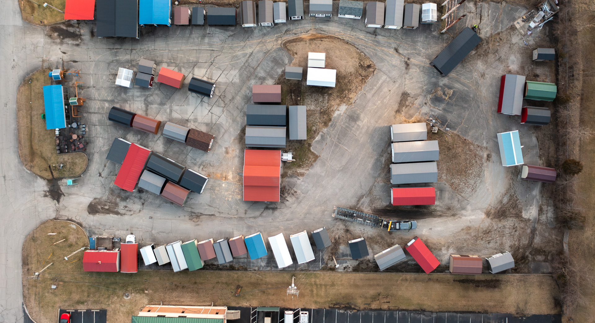 shed delivery aerial photo capturing a loading truck loading up a Rollin Mini Barns shed to deliver to a customer
